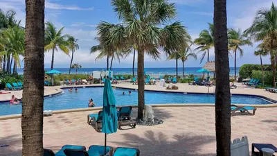a pool at a resort with palm trees at The Tides Apartments on the beach in Hollywood