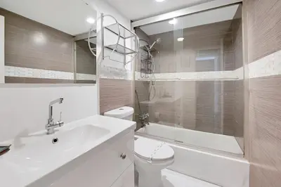a white bathroom with a toilet and a sink at The Tides Apartments on the beach in Hollywood