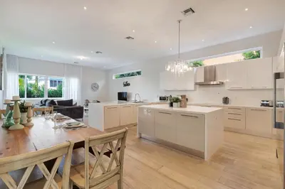 a kitchen and dining room with a table and chairs at Modern villa w lake view heated pool grill in Hollywood
