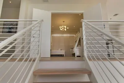 a staircase in a house with white railings at Modern villa w lake view heated pool grill in Hollywood