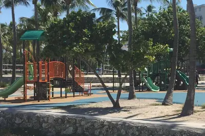 a park with a playground with slides and trees at Heart of South Beach / Modern Apartment / Ocean Drive - Carlyle in Miami Beach