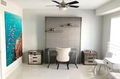 a dining room with a table and a ceiling fan at Heart of South Beach / Modern Apartment / Ocean Drive - Carlyle in Miami Beach
