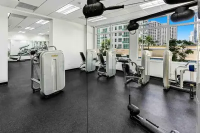 a gym with treadmills and machines in a building at Beautiful Apartments in Miami Brickell in Miami