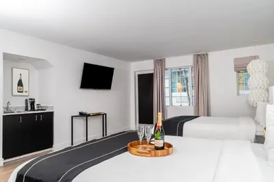 a hotel room with a bed with a bottle of champagne at Essex House Hotel in Miami Beach