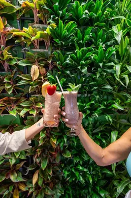 two people holding up two drinks with a cherry on top at Circa 39 Miami Beach in Miami Beach