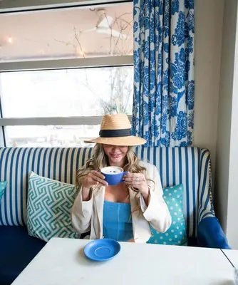 a woman sitting on a couch holding a cup of coffee at Circa 39 Miami Beach in Miami Beach