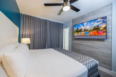 a bedroom with a white bed and a ceiling fan at Colony Hotel in Miami Beach