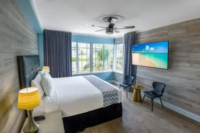 a hotel room with a bed and a large window at Colony Hotel in Miami Beach