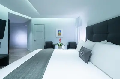 a bedroom with a large white bed with a black headboard at Kent Hotel in Miami Beach