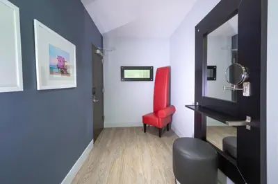 a room with a red chair and a mirror at Kent Hotel in Miami Beach