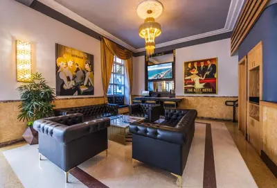 a living room with leather furniture and a piano at Kent Hotel in Miami Beach