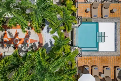 an aerial view of a resort with a swimming pool and palm trees at Balfour Miami Beach, a Registry Collection Hotel in Miami Beach