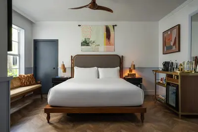 a bedroom with a large white bed and a couch at Balfour Miami Beach, a Registry Collection Hotel in Miami Beach