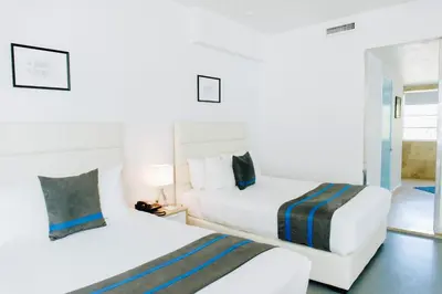 a hotel room with two beds and a mirror at Aqua Hotel & Suites in Miami Beach