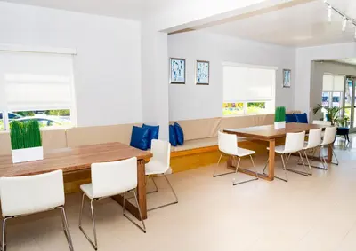 a dining room with a wooden table and white chairs at Aqua Hotel & Suites in Miami Beach