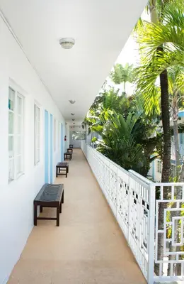 a corridor of a building with benches and palm trees at Aqua Hotel & Suites in Miami Beach