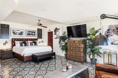 a bedroom with a bed and a tv on a wall at National Hotel, An Adult Only Oceanfront Resort in Miami Beach