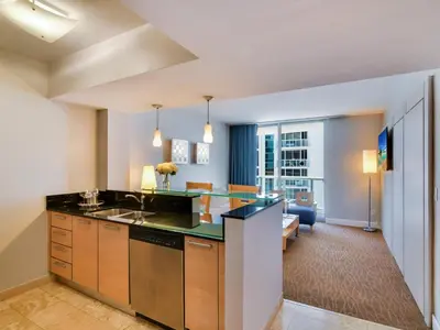 an apartment kitchen with a sink and a living room at Marenas Beach Resort in Miami Beach