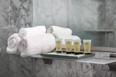 a tray with towels and cups on a table in a bathroom at Century Hotel in Miami Beach