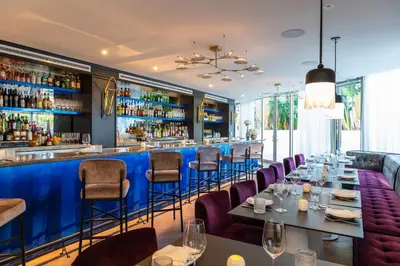a restaurant with a blue bar with tables and chairs at Park Central South Beach in Miami Beach