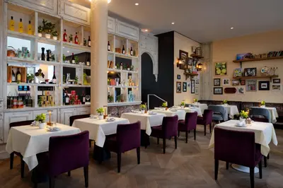 a dining room with white tables and purple chairs at Park Central South Beach in Miami Beach