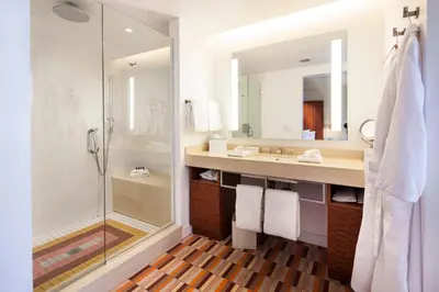 a bathroom with a shower and a sink and a mirror at The Tony Hotel South Beach in Miami Beach