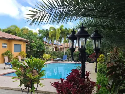 a swimming pool with a street light next to a house at Yuli's Home in Miami