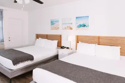 two beds in a bedroom with white walls at Lorraine Hotel in Miami Beach