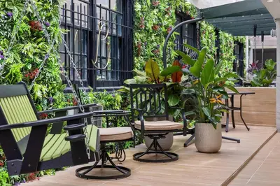 a patio with tables and chairs and plants at Beacon South Beach Hotel in Miami Beach
