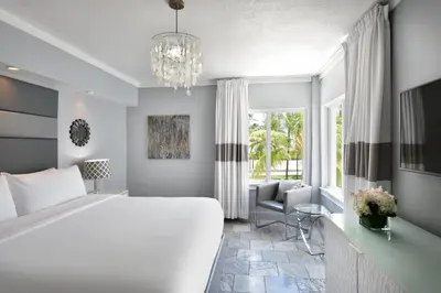 a bedroom with a large bed and a chandelier at Beacon South Beach Hotel in Miami Beach