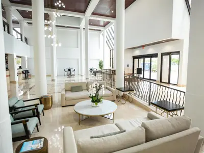 a living room with couches and a table at Regency Miami Airport by Sonesta in Miami