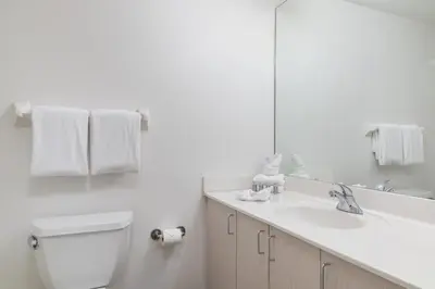 a bathroom with a toilet and a sink and a mirror at Fortune House Hotel Suites in Miami