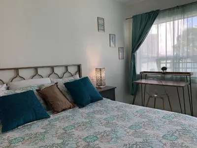 a bedroom with a bed with blue pillows and a window at International Inn on the Bay in Miami Beach