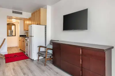 a kitchen with a refrigerator and a tv on a wall at Ramada Plaza by Wyndham Marco Polo Beach Resort in Miami Beach