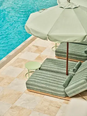 two chairs with an umbrella next to a pool at The Shelborne by Proper, a Member of Design Hotels in Miami Beach