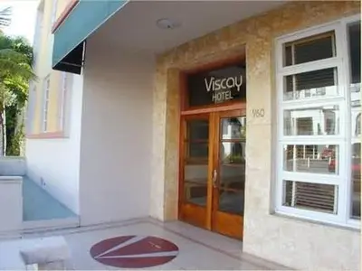 a building with a wooden door and a sign on it at Viscay Hotel in Miami Beach