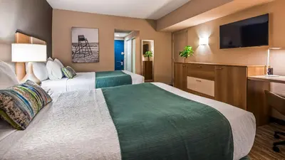 a hotel room with two beds and a flat screen tv at Best Western Plus Atlantic Beach Resort in Miami Beach