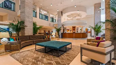a lobby at a hotel with couches and a table at Best Western Plus Atlantic Beach Resort in Miami Beach