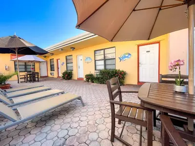 a patio with tables and chairs and an umbrella at Greniers in Hollywood