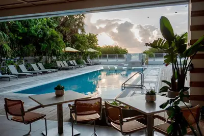 a patio with a pool and tables and chairs at MB Hotel, Trademark Collection by Wyndham in Miami Beach