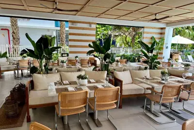 a restaurant with tables and chairs and plants at MB Hotel, Trademark Collection by Wyndham in Miami Beach