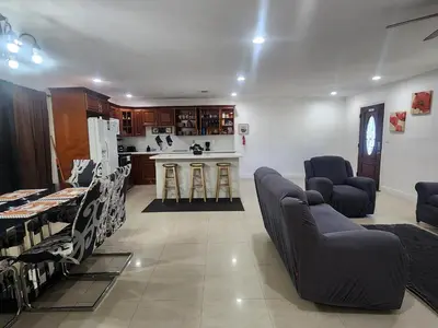 a living room with two couches and a kitchen at The Jazzy Escape in Miami