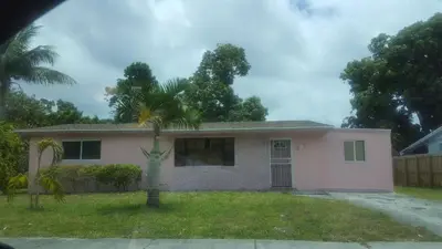 a house with a palm tree in the yard at The Jazzy Escape in Miami