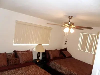 a bedroom with two beds and a ceiling fan at The Jazzy Escape in Miami