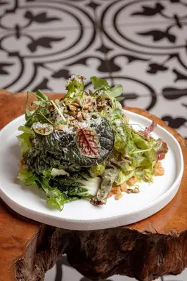 a salad on a white plate on a table at Casa Faena Miami Beach in Miami Beach
