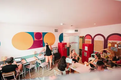a group of people sitting at tables in a restaurant at Viajero Miami in Miami Beach