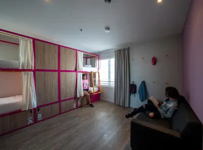 a woman sitting on a couch in a room with bunk beds at Viajero Miami in Miami Beach