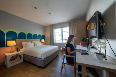 a woman sitting at a desk in a hotel room at Viajero Miami in Miami Beach