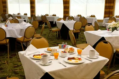 a dining room with tables with plates of food at Sea View Hotel in Miami Beach