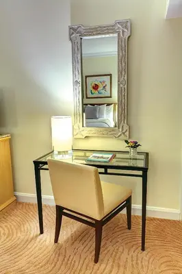 a room with a desk with a mirror and a chair at Sea View Hotel in Miami Beach